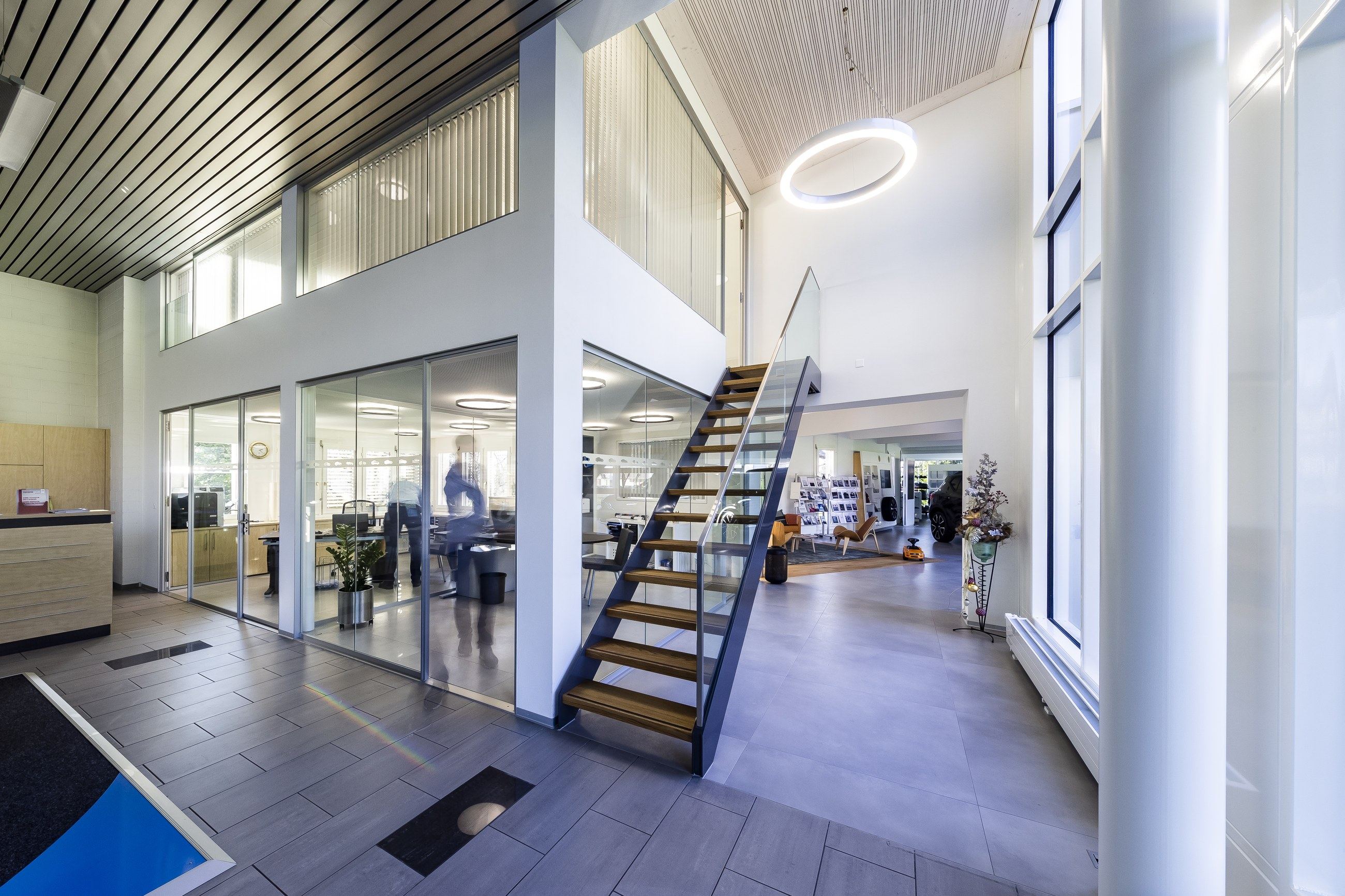 Der Showroom der Garage Zimmermann mit offener Treppe und transparenten Büros