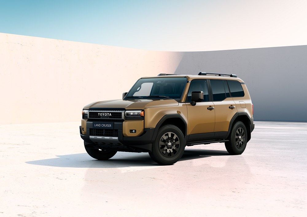 Der neue Toyota Land Cruiser in Sandfarbe vor hellem Hintergrund