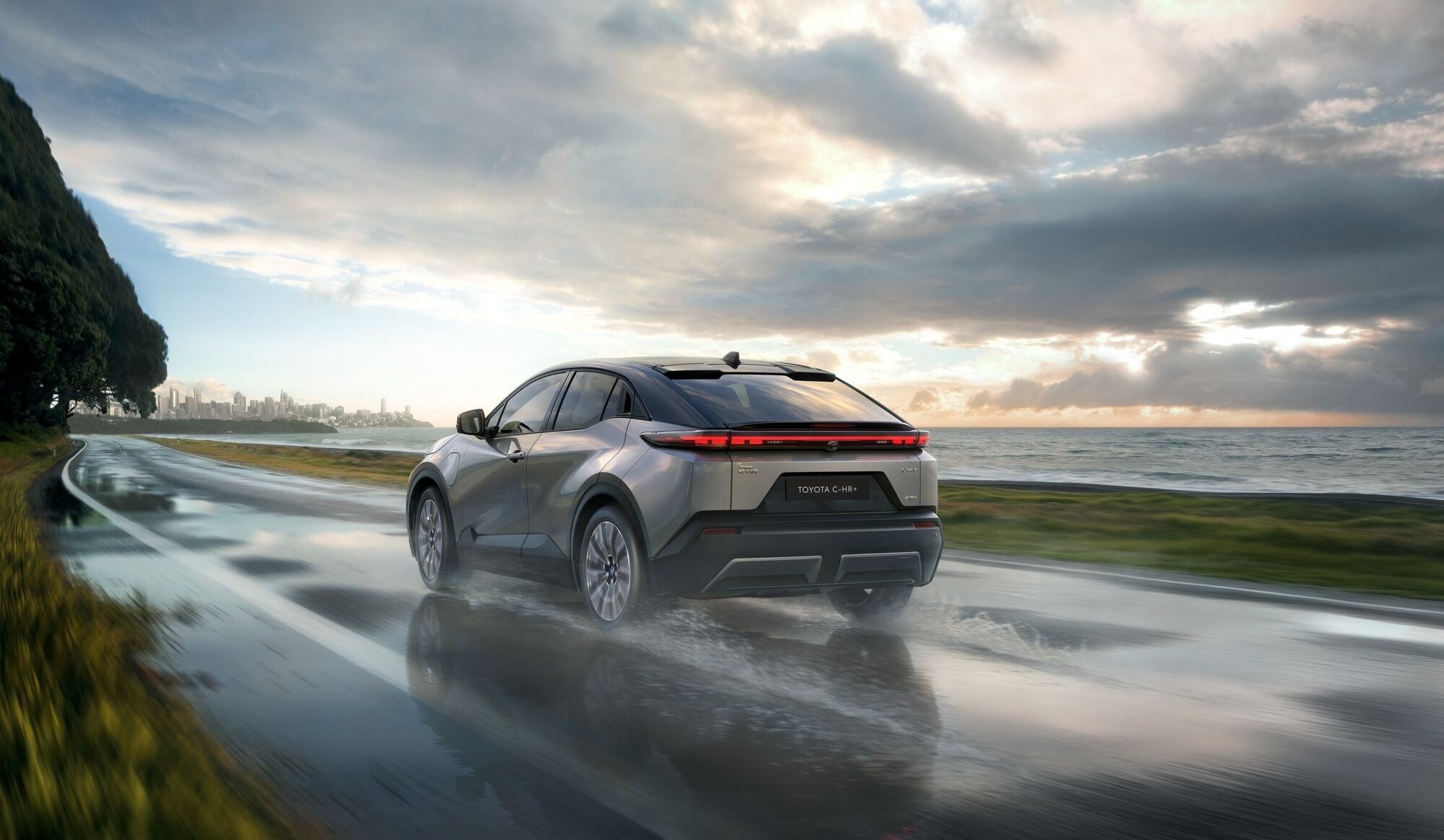 Toyota C-HR+ in Fahrt auf nasser Strasse