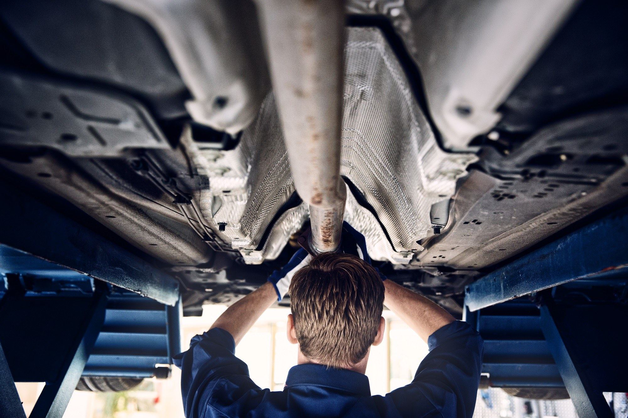 Mechaniker arbeitet auf der Hebebühne am Unterboden eines Volvo